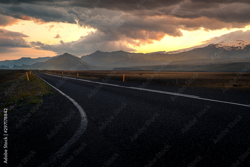 Asphalt road to the mountain at the sunset.