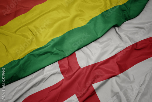 waving colorful flag of england and national flag of bolivia.