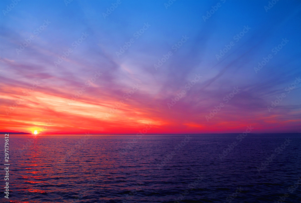 Fototapeta premium Colorful amazing sunset over the sea. Natural sunset, bright dramatic sky, red, pink and blue tones