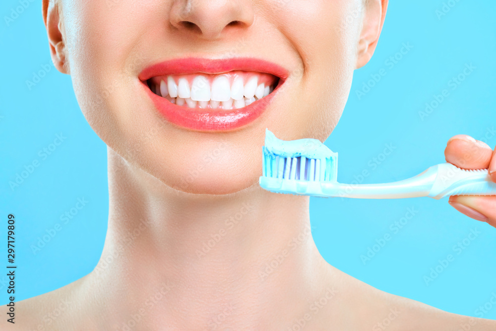 Young beautiful woman is engaged in cleaning teeth. Beautiful smile healthy white teeth. A girl holds a toothbrush. The concept of oral hygiene. Promotional image for a stomatology, dental clinic. Young beautiful woman is engaged in cleaning teeth. Beautiful smile healthy white teeth. A girl holds a toothbrush. The concept of oral hygiene. Promotional image for a stomatology, dental clinic.