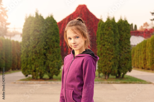 Outdoors leisure. Girl standing in the autumn park smiling relaxed