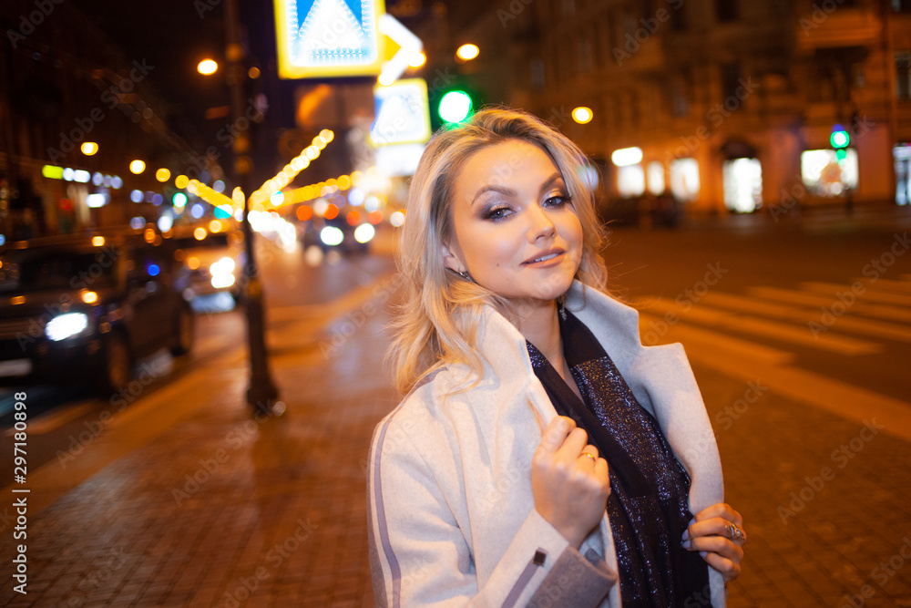 Fototapeta premium Stylish and elegant young woman in a beige coat on the city .