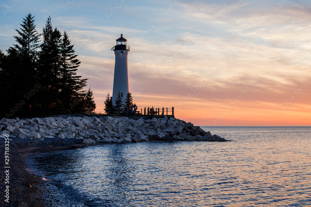 lighthouse in bay at sunset
