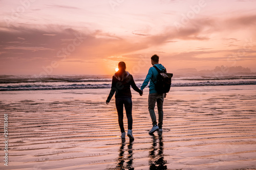 Tofino Vancouver Island, sunset at cox bay with surfers by the ocean during fall season Canada