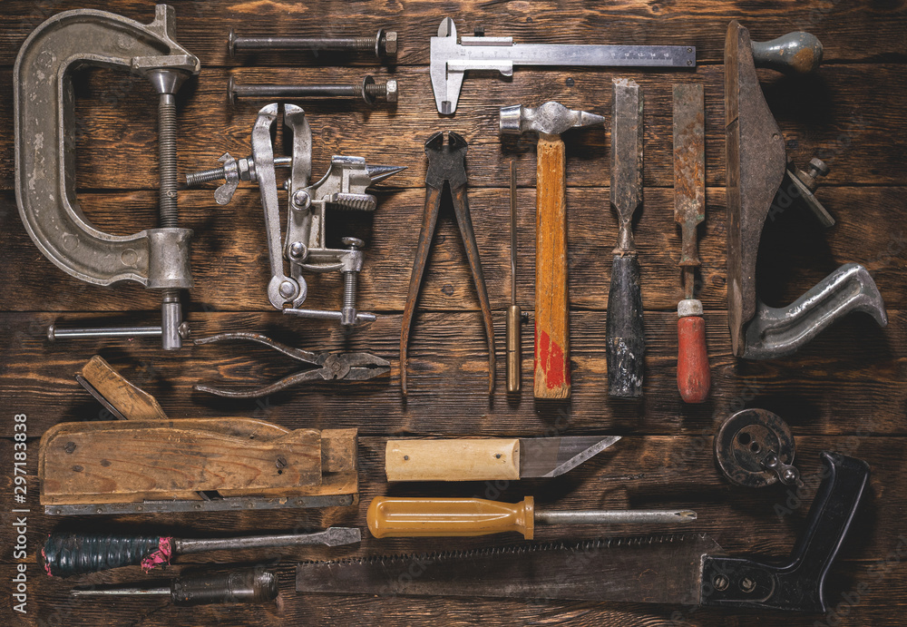 Old carpentry work tools on a brown wooden table background. - obrazy, fototapety, plakaty 