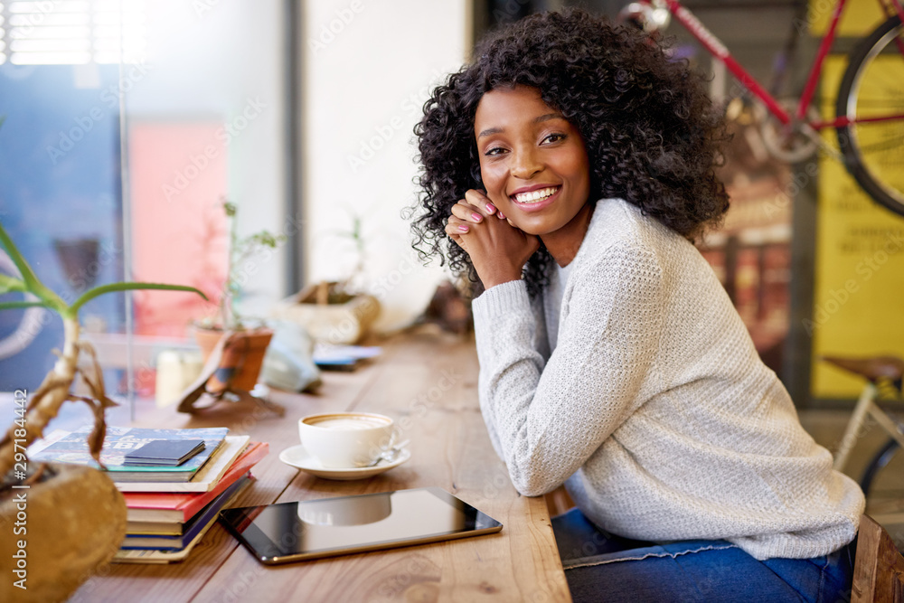 Young African American woman smiling while relaxing in a cafe Young African American woman smiling while relaxing in a cafe