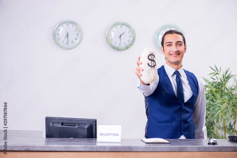 Young man receptionist at the hotel counter