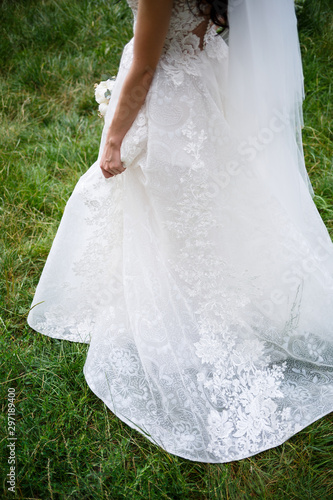 the bride holds in her hands a beautiful wedding dress