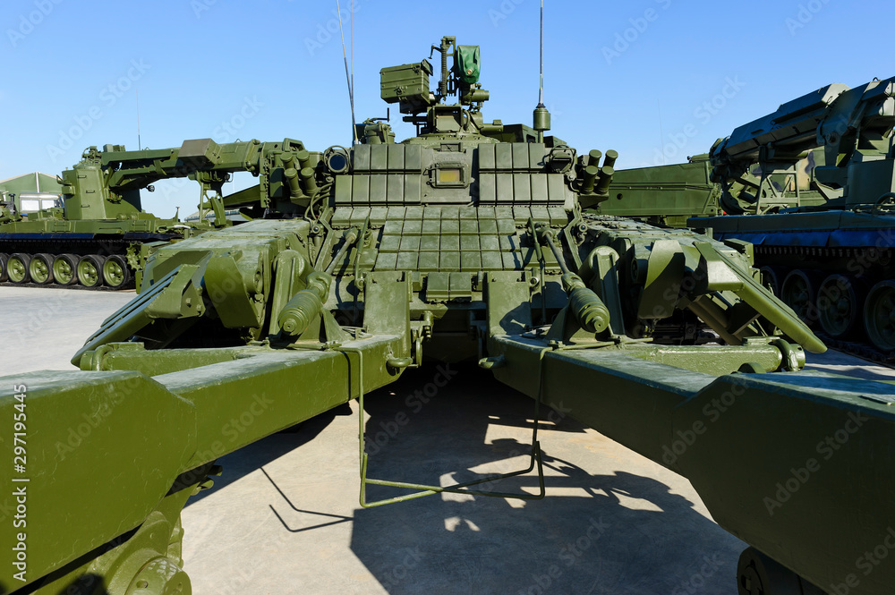 Demining military vehicle, armored mine clearing tank, mine detector transportation with other military engineering machines and blue sky on background, heavy industry Demining military vehicle, armored mine clearing tank, mine detector transportation with other military engineering machines and blue sky on background, heavy industry