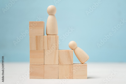 Photos Wooden figures of people on career ladder. One of them gives up.