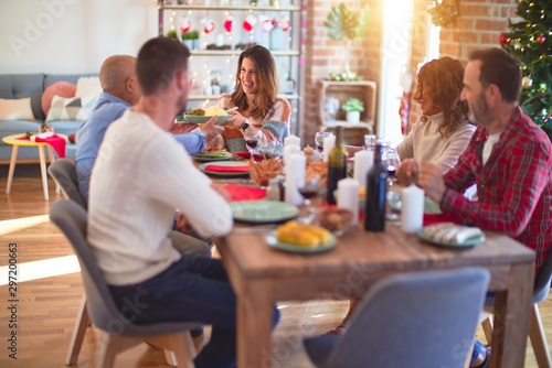 Beautiful family smiling happy and confident. Eating roasted turkey celebrating Christmas at home