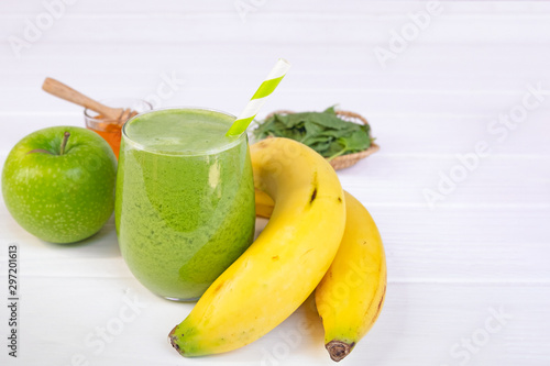 Banana mix spinach apple smoothie green juice beverage healthy the taste yummy in glass for on white wood background.