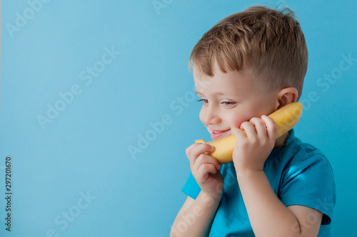 Little Boy tries to speak by means of a banana instead of phone.