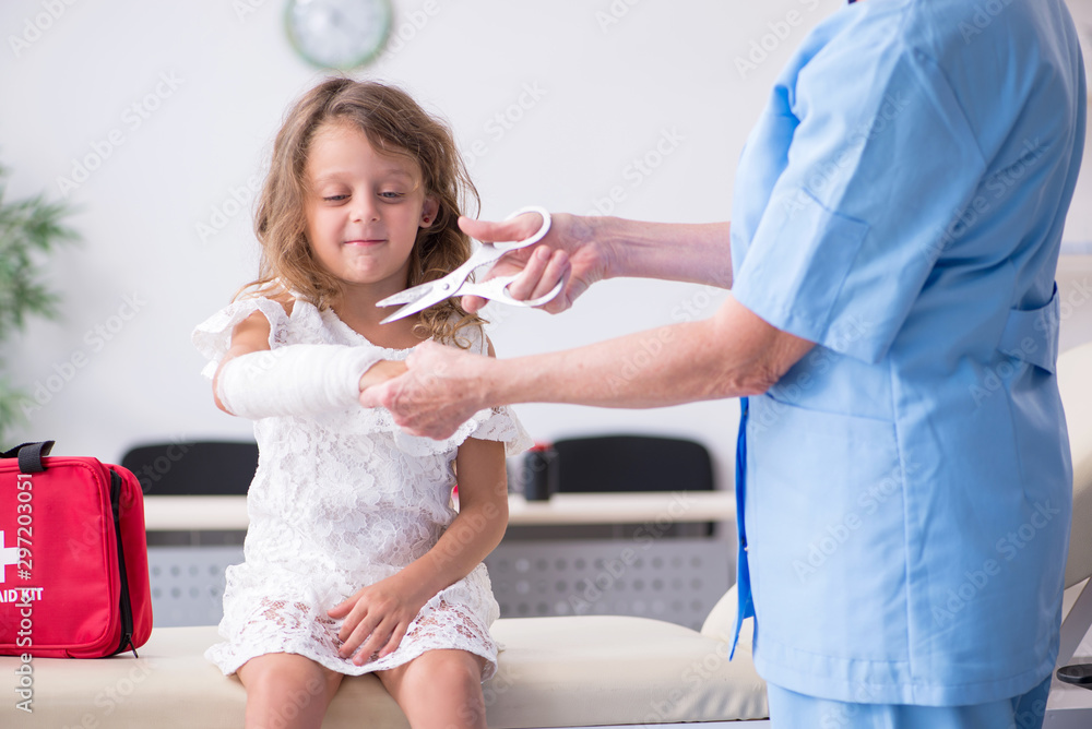 Little girl visiting old female doctor Little girl visiting old female doctor