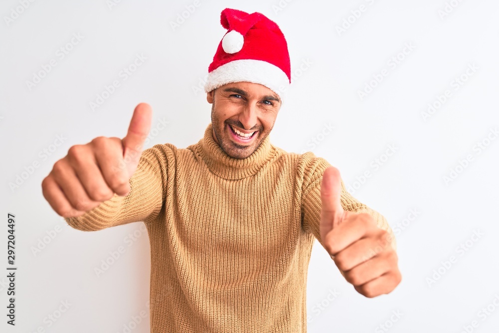 Young handsome man wearing christmas and turtleneck sweater over isolated background approving doing positive gesture with hand, thumbs up smiling and happy for success. Winner gesture. Young handsome man wearing christmas and turtleneck sweater over isolated background approving doing positive gesture with hand, thumbs up smiling and happy for success. Winner gesture.