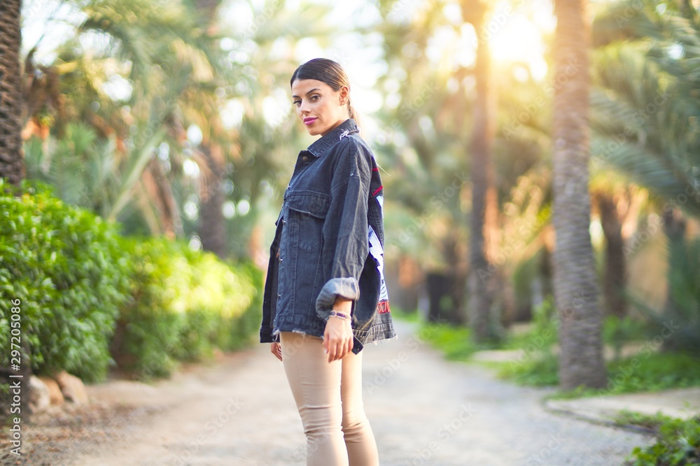 Young beautiful woman wearing denim jacket standing at the town park Young beautiful woman wearing denim jacket standing at the town park
