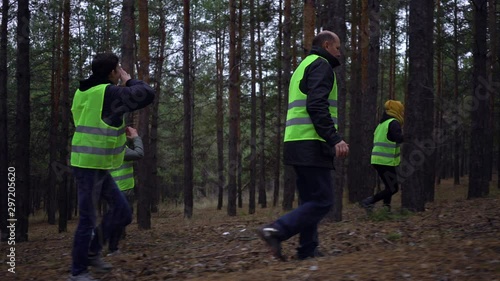 group of volunteers in green vests went in search of missing persons in a pine forest