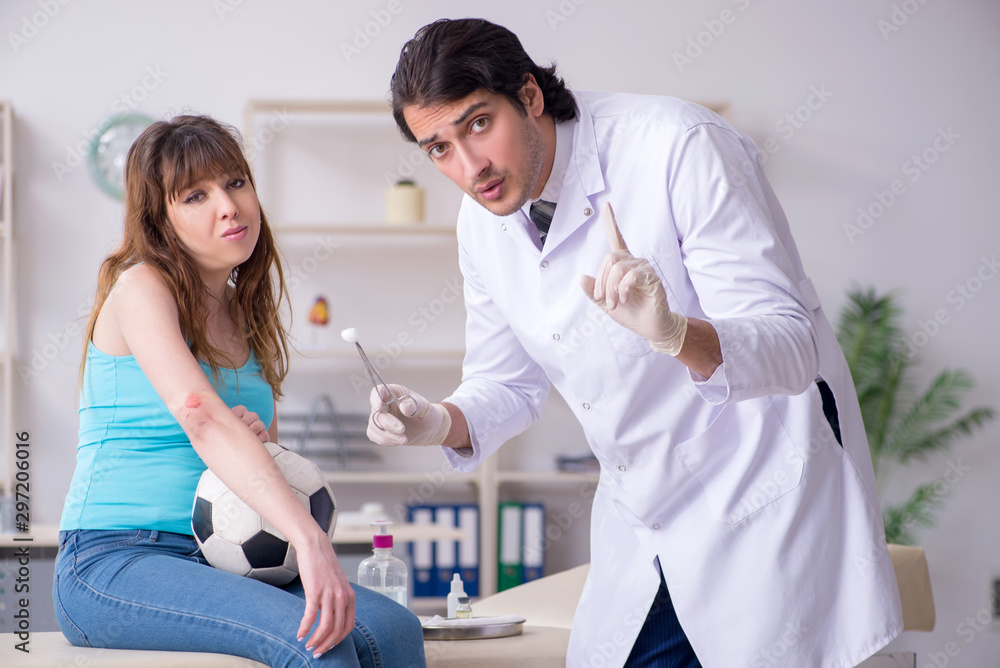 Young arm injured woman visiting young doctor traumatologist