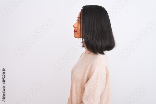 Young chinese woman wearing turtleneck sweater standing over isolated white background looking to side, relax profile pose with natural face and confident smile.