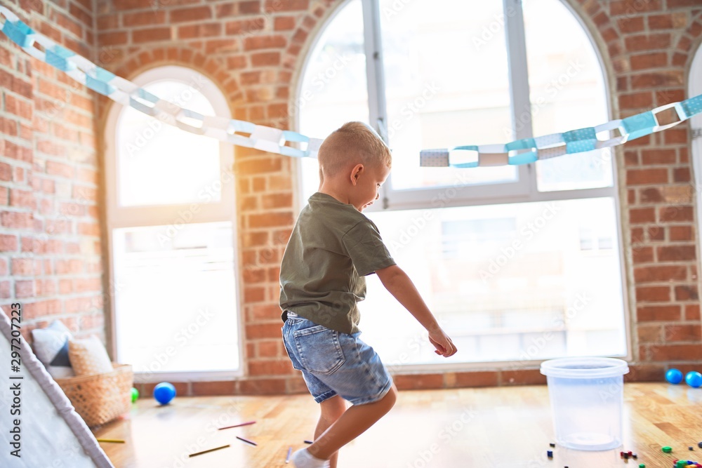 Young caucasian kid playing at kindergarten with toys. Preschooler boy happy at playroom. Young caucasian kid playing at kindergarten with toys. Preschooler boy happy at playroom.