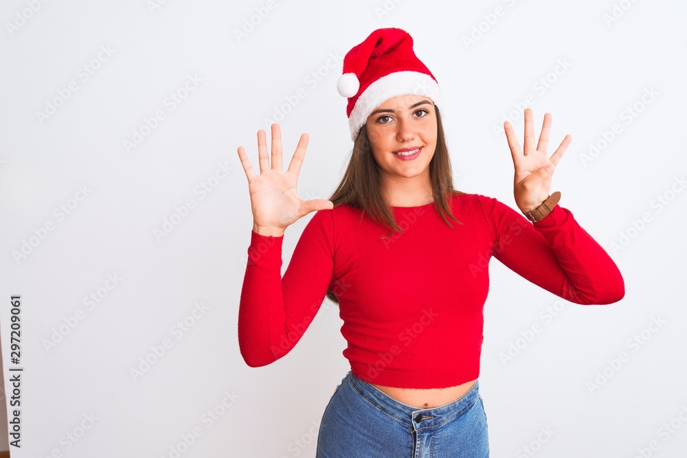 Young beautiful girl wearing Christmas Santa hat standing over isolated white background showing and pointing up with fingers number nine while smiling confident and happy. Young beautiful girl wearing Christmas Santa hat standing over isolated white background showing and pointing up with fingers number nine while smiling confident and happy.