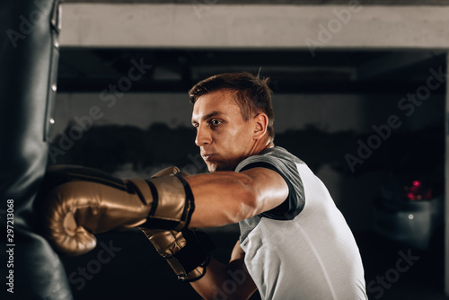 Dramatic lighting on a martial arts fighter punching in the gym
