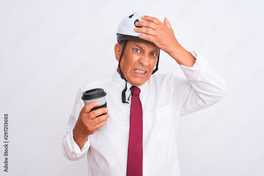 Senior businessman wearing bike helmet drinking coffee over isolated white background stressed with hand on head, shocked with shame and surprise face, angry and frustrated. Fear and upset Senior businessman wearing bike helmet drinking coffee over isolated white background stressed with hand on head, shocked with shame and surprise face, angry and frustrated. Fear and upset