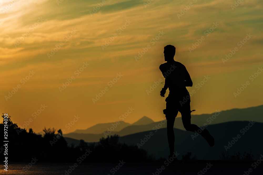 Sporty man jogging over blue sky on mountain path