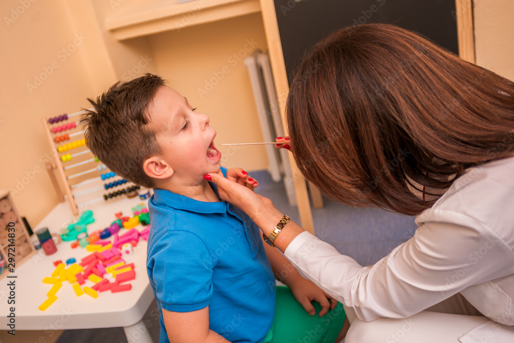 Female Pediatrician check's the throat and mouth of a young cute boy. Female Pediatrician check's the throat and mouth of a young cute boy.