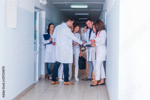 Group of medical staff, team doctors and nurses posing in the hallway of a hospital, clinic.