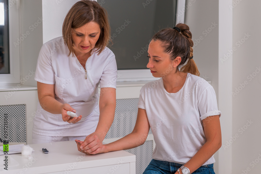 Fototapeta premium Doctor checking blood sugar level with a glucometer girls levels.