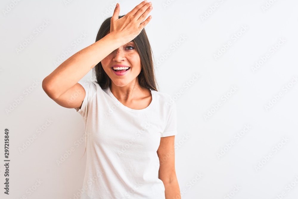 Young beautiful woman wearing casual t-shirt standing over isolated white background surprised with hand on head for mistake, remember error. Forgot, bad memory concept.
