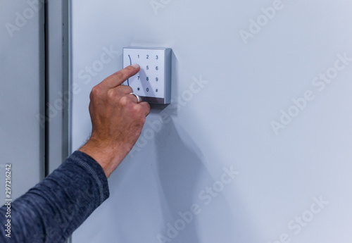 Fotografi Man typing numbers on a white numeric keypad