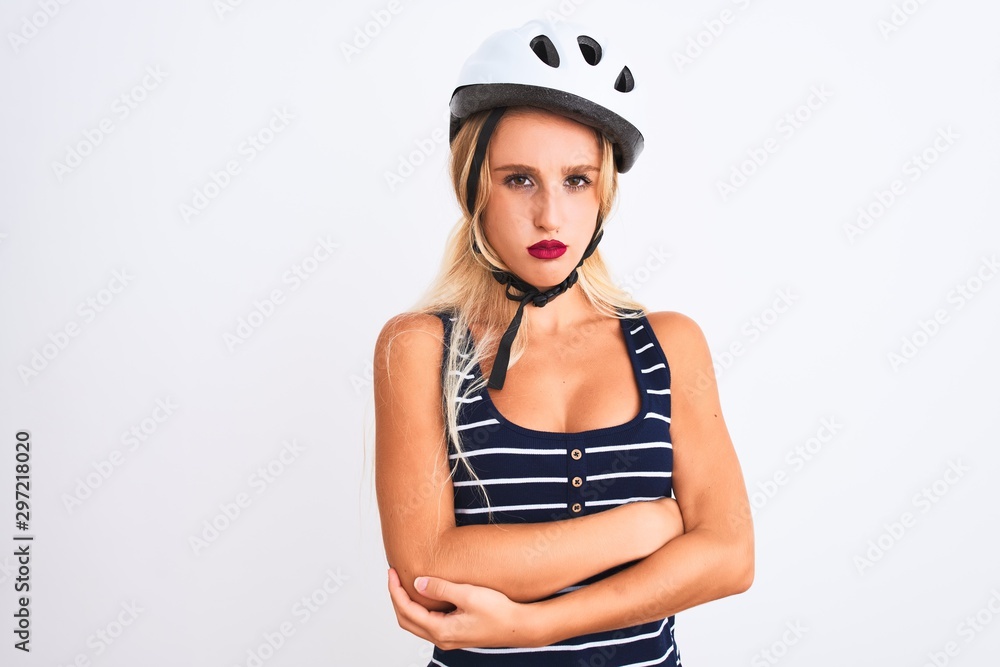 Young beautiful woman wearing bike helmet standing over isolated white background skeptic and nervous, disapproving expression on face with crossed arms. Negative person. Young beautiful woman wearing bike helmet standing over isolated white background skeptic and nervous, disapproving expression on face with crossed arms. Negative person.