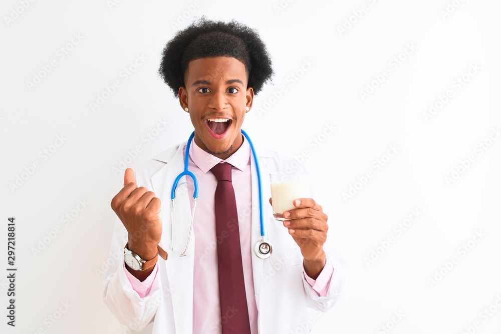 Young african american doctor man drinking glass of milk over isolated white background screaming proud and celebrating victory and success very excited, cheering emotion Young african american doctor man drinking glass of milk over isolated white background screaming proud and celebrating victory and success very excited, cheering emotion