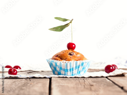 Freshly baked cherry muffins closeup on a rustic table