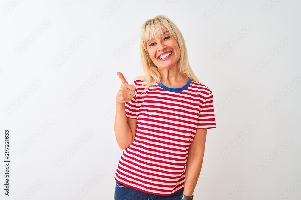 Middle age woman wearing casual striped t-shirt standing over isolated white background doing happy thumbs up gesture with hand. Approving expression looking at the camera showing success. Middle age woman wearing casual striped t-shirt standing over isolated white background doing happy thumbs up gesture with hand. Approving expression looking at the camera showing success.