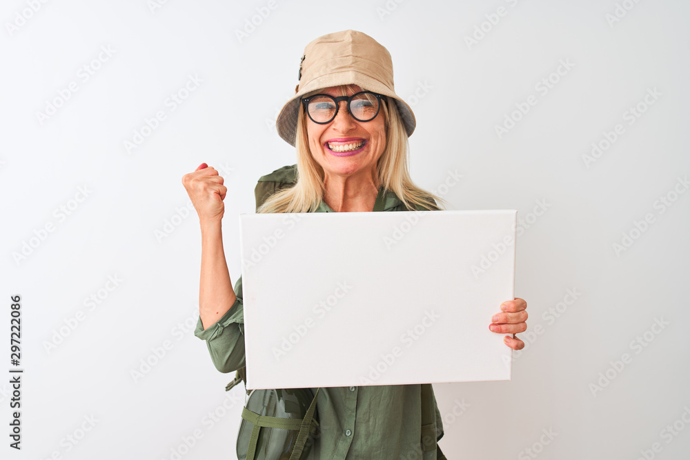 Senior hiker woman wearing canteen hat holding banner over isolated white background screaming proud and celebrating victory and success very excited, cheering emotion Senior hiker woman wearing canteen hat holding banner over isolated white background screaming proud and celebrating victory and success very excited, cheering emotion