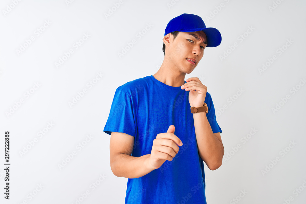 Chinese deliveryman wearing blue t-shirt and cap standing over isolated white background disgusted expression, displeased and fearful doing disgust face because aversion reaction. With hands raised