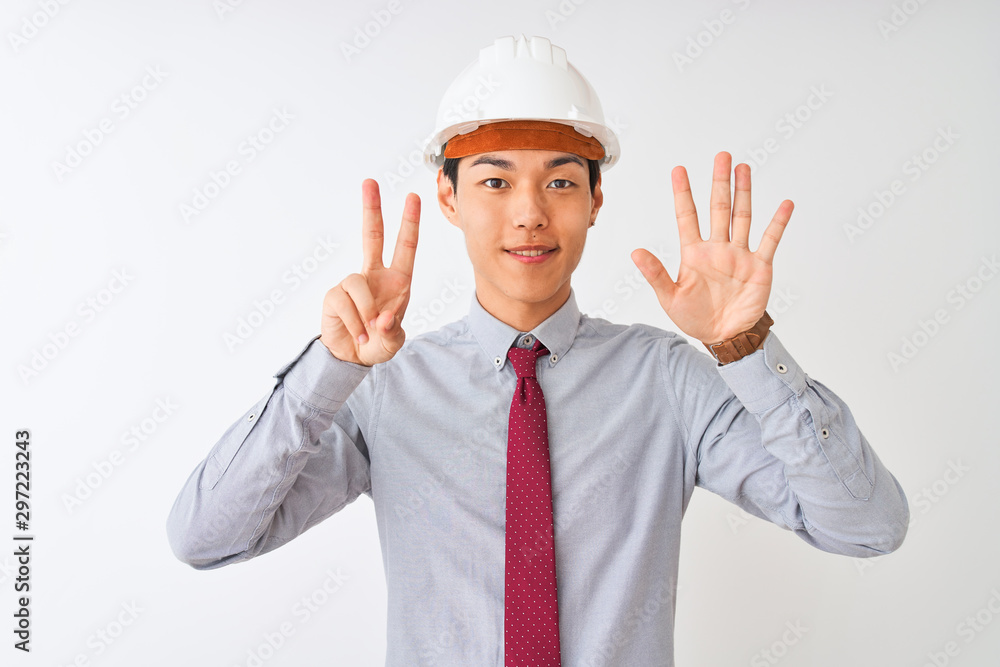 Chinese architect man wearing tie and helmet standing over isolated white background showing and pointing up with fingers number seven while smiling confident and happy. Chinese architect man wearing tie and helmet standing over isolated white background showing and pointing up with fingers number seven while smiling confident and happy.