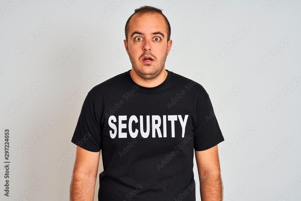 Young safeguard man wearing security uniform standing over isolated white background scared in shock with a surprise face, afraid and excited with fear expression Young safeguard man wearing security uniform standing over isolated white background scared in shock with a surprise face, afraid and excited with fear expression