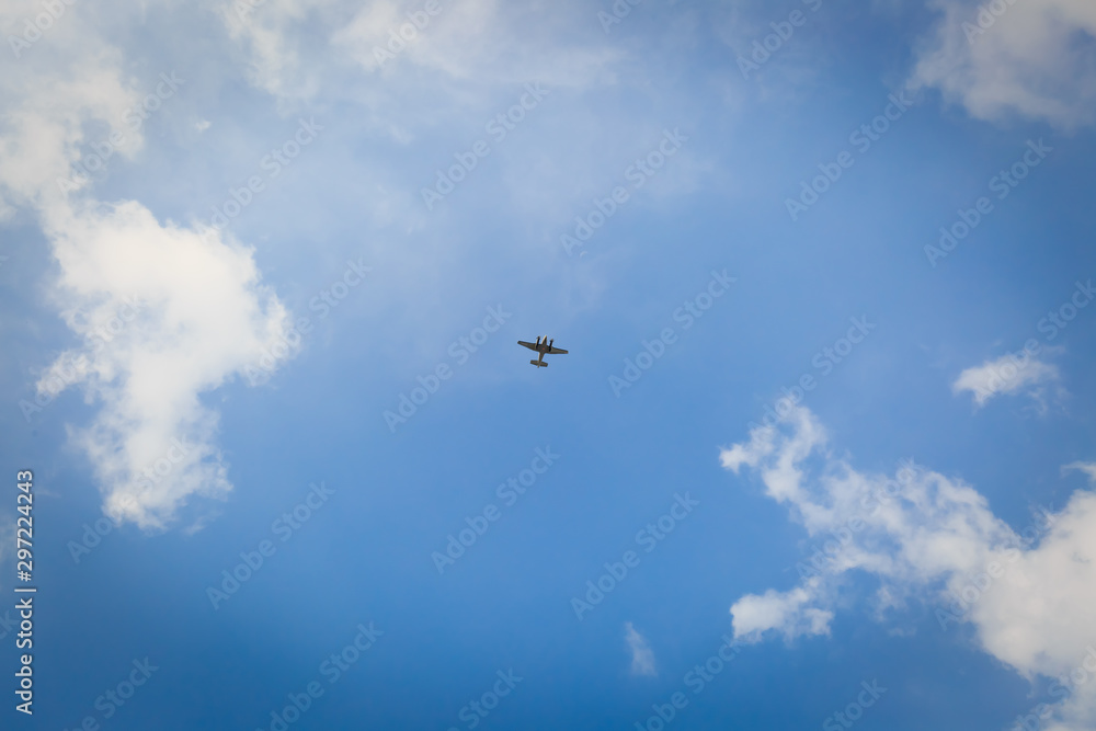 Small Flying Plane in the blue sky with cloud