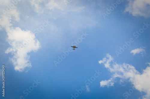 Small Flying Plane in the blue sky with cloud
