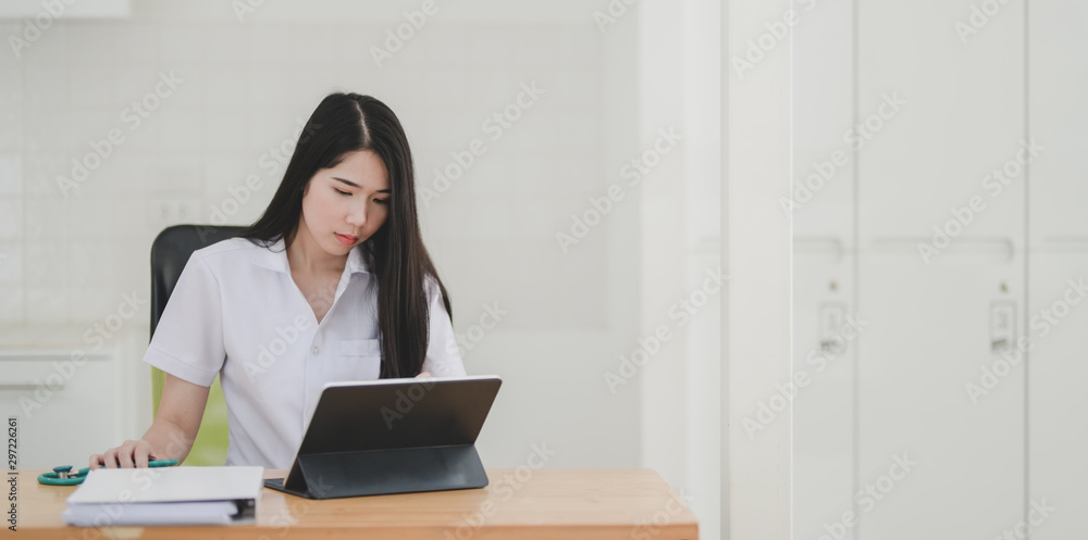 Young female doctor examining and analysing the patient chart with digital tablet Young female doctor examining and analysing the patient chart with digital tablet