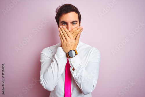 Quadro su tela Young handsome businessman wearing shirt and tie standing over isolated pink background shocked covering mouth with hands for mistake