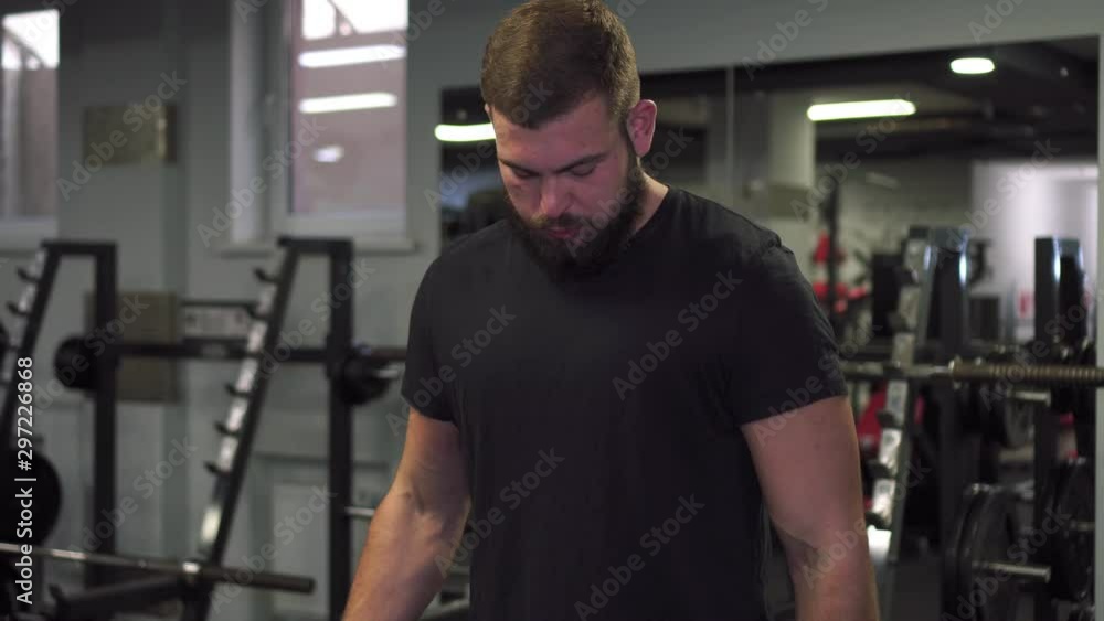 A man is training with small dumbbells in the gym. A man is training with small dumbbells in the gym.