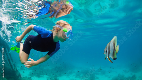 Happy family - active kid in snorkeling mask dive underwater  see tropical fish Platax   Batfish   in coral reef sea pool. Travel adventure  swimming activity on summer beach vacation with child.