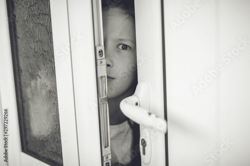 Scared girl kid in opened door. Safety concept