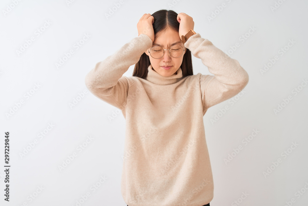 Young chinese woman wearing turtleneck sweater and glasses over isolated white background suffering from headache desperate and stressed because pain and migraine. Hands on head. Young chinese woman wearing turtleneck sweater and glasses over isolated white background suffering from headache desperate and stressed because pain and migraine. Hands on head.