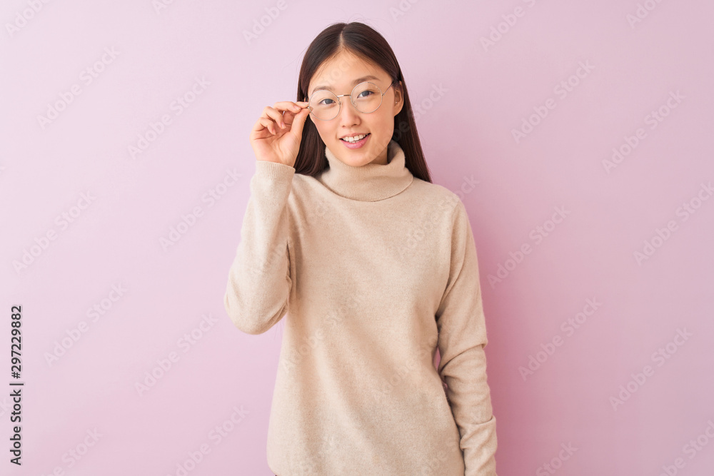 Young chinese woman wearing turtleneck sweater and glasses over isolated pink background with a happy face standing and smiling with a confident smile showing teeth Young chinese woman wearing turtleneck sweater and glasses over isolated pink background with a happy face standing and smiling with a confident smile showing teeth